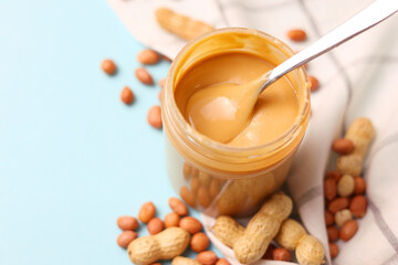 peanut butter and raw peanuts on a colored background