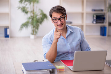 Fototapeta premium Young male employee working in the office
