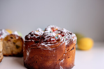 Easter Kraffin on a light background with colored, bright eggs. Cake with raisins, chocolate, nuts