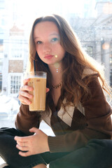 Close-up of happy woman drinking smoothie with straw, looking at camera, in slow motion. High quality FullHD footage