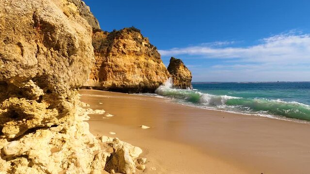 View of idyllic nature landscape with rocky cliff shore and waves crashing on. Camillo beach in Lagos. West Atlantic coast of Algarve region, south of Portugal.