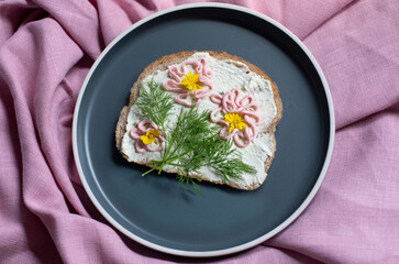 creative sandwich with soft cheese and pink pasta tarama greens, flowers