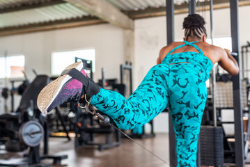 Beautiful woman training leg muscles on the pulley.