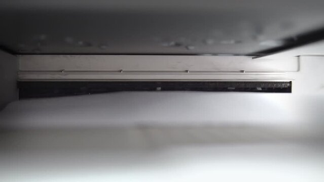Closeup of printer, photocopier print or copy documents, sheets of paper on the laser MFP printer. Printing process in a storehouse or office