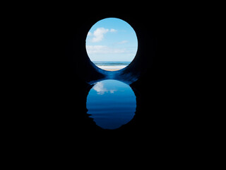 View on the ocean from a pipe or round shape hole with reflection inside the pipe. Abstract nature concept. Blue cool tone. Artificial framing of nature.