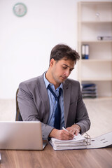 Fototapeta premium Young male employee working in the office