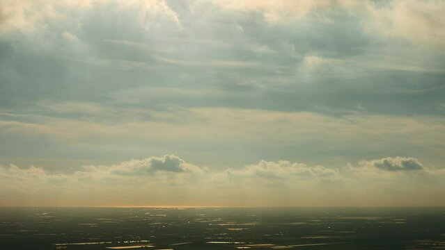 Time lapse at sunset with fast moving clouds and the horizon. Paragliders fly in the cloudy sky. Sport gives a feeling of tranquility, peace, strength and freedom in the air.