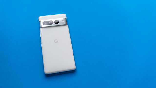 Los Angeles, California – March 29, 2023: Google Pixel 7 Pro, in Snow white, on a plain blue background. The phone is face down with the back shown.
