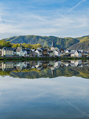Fototapeta premium Vertical shot of Briedern village houses and mountain reflection on Moselle river in Cochem-Zell district, Germany