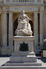 Naklejka premium A marble statue of Queen Victoria by the Sicilian artist Giuseppe Valenti stands in front of the National Library in Republic Square - Valletta, Malta