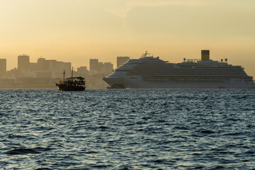 Obraz premium Transatlantic ship in Guanabara Bay in Rio de Janeiro, Brazil with a hill in the background. Beautiful landscape with the sea at sunset. Sailing boats and speedboats in the bay