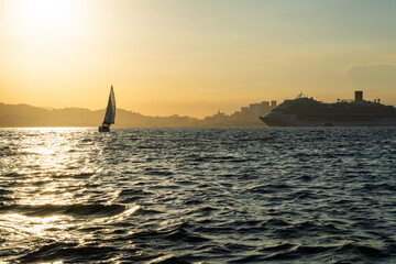 Transatlantic ship in Guanabara Bay in Rio de Janeiro, Brazil with a hill in the background. Beautiful landscape with the sea at sunset. Sailing boats and speedboats in the bay