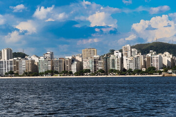 Fototapeta premium Guanabara Bay in Rio de Janeiro, Brazil with a hill in the background. Beautiful landscape and hill with the sea. Sailing boats in the bay. Icaraí beach, Niterói in the background