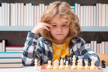 Play chess. Chess school. Child think about chess game. Intelligent, smart and clever school kid...