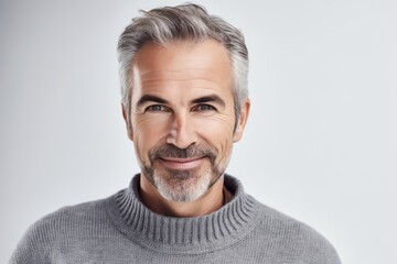 Serenity in a smile: 45-year-old man with gray hair and beard wearing gray wool sweater on white background. Generative AI