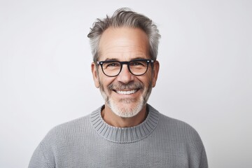 Serenely smiling middle-aged man with gray hair and beard in wool sweater on white background.