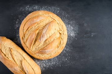 bread and flour, two freshly baked loaves, freshly baked bread on a stone table