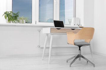 Comfortable workplace near window in stylish room. Home office