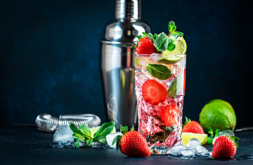 Strawberry Mojito cocktail drink with lime, white rum, soda, cane sugar, mint, and ice in glass on...