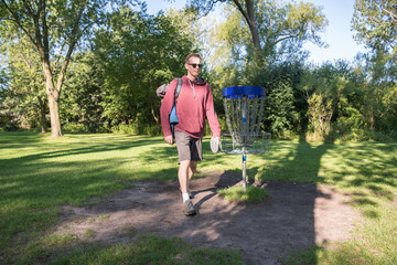 Fototapeta premium Disc golf is a flying disc sport in which players throw a disc at a target; played using rules like golfs. 