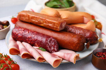 Different types of tasty sausages and ingredients on white table, closeup