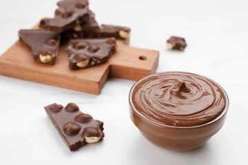 Pieces of tasty chocolate and sweet paste on white table, closeup