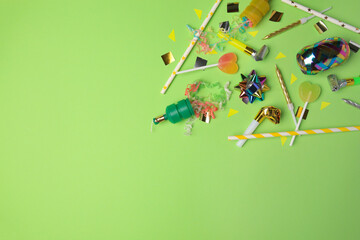 Party poppers with colorful streamers, blowers and festive decor on light green background, flat...