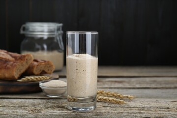 Glass with fresh sourdough on wooden table