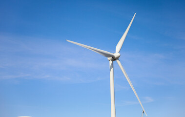 wind turbine standing tall against a clear blue sky, symbolizing sustainability, renewable energy, and the use of alternative energy resources in industry