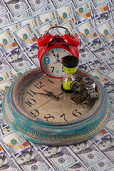 Various watches and banknotes in denominations of 100 American dollars on a black background