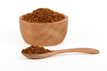 Instant coffee on wooden spoon and bowl isolated on white background. Instant coffee is a beverage derived from brewed coffee beans that enables people to quickly prepare hot coffee.