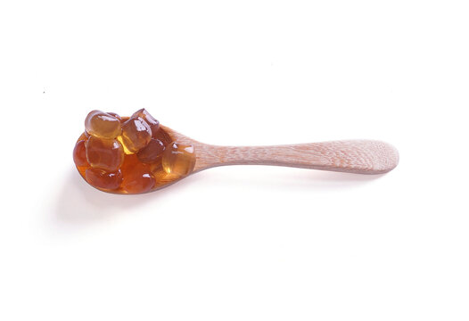 Top view of Tapioca Pearls (Bubble Tea) on wooden spoon isolated on white background, It's small chewy balls made from tapioca starch, Commonly used as a topping in milk tea drinks.