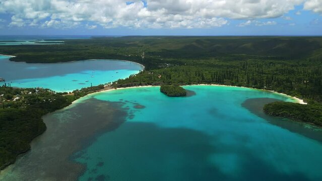 Wide view of Kuto, Kanumera Bays and Sacred Rock, Isle of Pines. Aerial flyover.