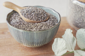 Black Chia seeds in wooden spoon and bowl, superfood healthy fiber food for gut health