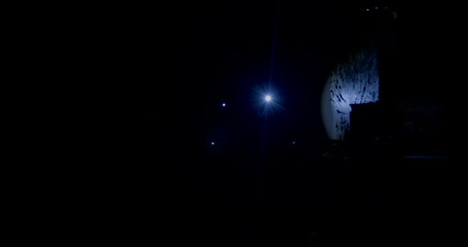 Personas caminando con linternas por un edificio de noche