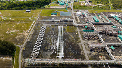 Large above ground tanks store oil and gas in an oil refinery. Borneo, Sabah, Malaysia. - obrazy, fototapety, plakaty