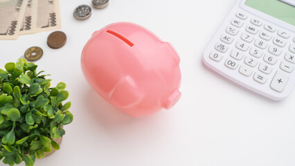 豚の貯金箱と電卓と現金(日本円)