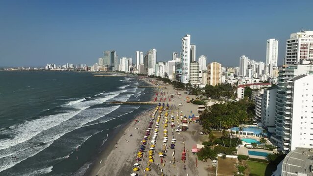 Flying over people and waves on the Playa De Bocagrande beach, in Cartagena, Colombia