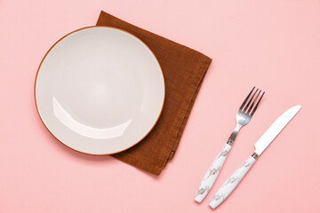 Table setting with napkin on pink background