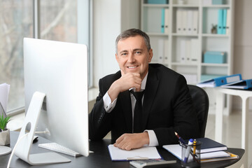 Fototapeta premium Mature accountant working at table in office