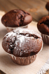 Tasty chocolate cupcakes on wooden background, closeup