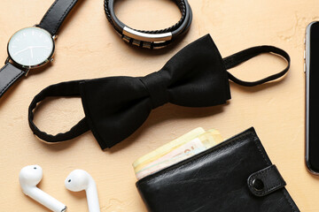 Set of stylish male accessories and earphones on color background, closeup