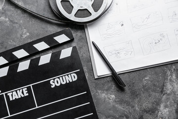 Storyboard with movie clapper and film reel on dark background