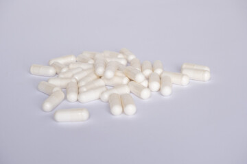 Food supplements or vitamins in capsules on a white background. White capsules on a white background close-up.