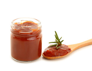 Jar and spoon with tasty tomato paste on white background