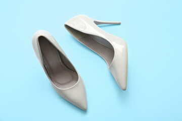 Stylish high heeled shoes on light blue background