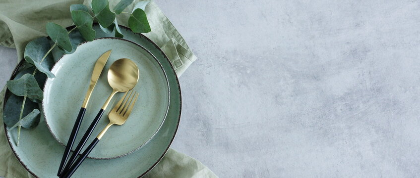 Modern minimal table place setting neutral green color on gray concrete background top view.Banner.  Space for text .  Modern kitchen.Scandinavian style.