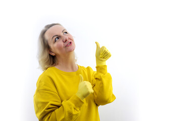 Smiling young redhead woman girl in casual yellow hoodie posing isolated on white background studio portrait. People sincere emotions lifestyle concept. Mock up copy space. Pointing thumbs up