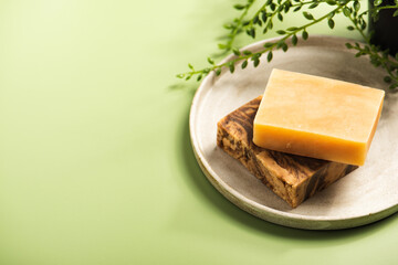 Handmade natural soap or shampoo bars on the concrete dish. Eco-friendly beauty skincare concept for small businesses. Zero waste gift on green background