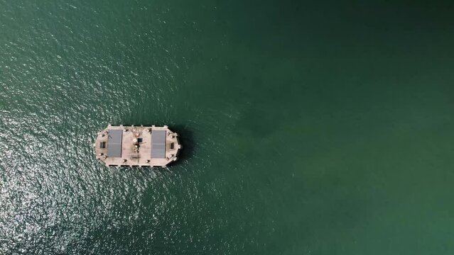 Aerial Birdseye view above Fawley power station cooling water outlet off the Calshot coast surrounded by shimmering sunlit emerald ocean